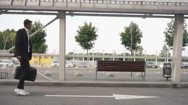 Attraktiv gerade am Flughafen angekommen bärtiger Geschäftsmann auf der Suche nach einem Taxi — Stockvideo