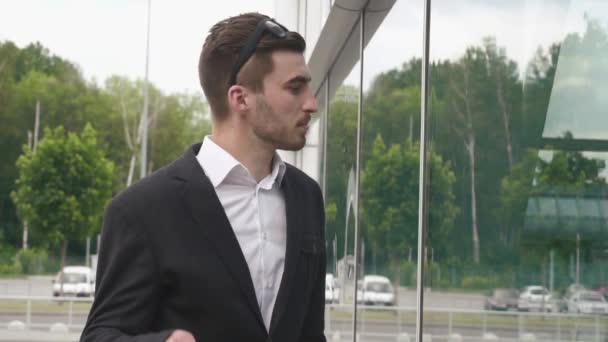 Mladý obchodník v glassesc shání svůj vzhled v zrcadlovém zamyšlení — Stock video