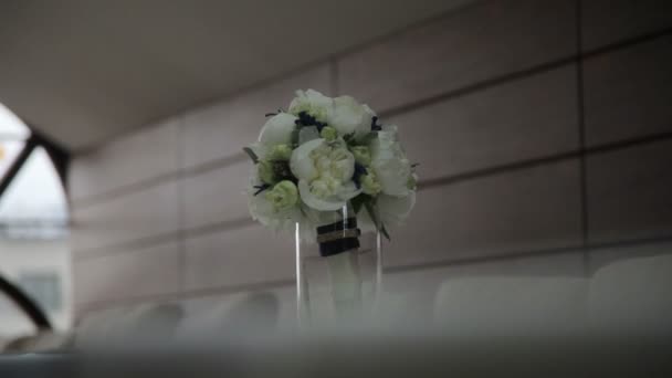 Belo buquê de noiva branco em pé em vidro na mesa, no interior do quarto de aparência moderna — Vídeo de Stock