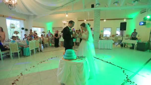 繊細な美しい花嫁とハンサムな新郎は、色とりどりなライトが付いているホールの結婚パーティーでお互いのケーキを与えます。31.08。 リヴィウ、ウクライナ、2015 年 — ストック動画