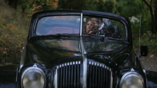 Genç çift siyah retro Cabrio eski model araba içinde yakışıklı adam yavaşça çekici kız öpücük — Stok video