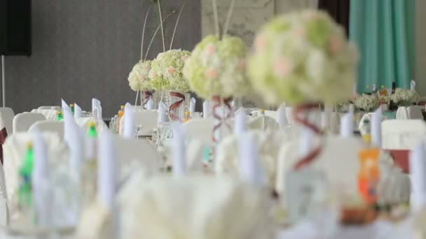 De instelling van de tabel op een luxe bruiloft receptie. Mooie bloem boeketten als centerpieces op tafel — Stockvideo