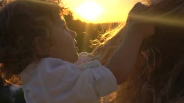 Anne ve çocuk bir çayırda gün batımında. Günbatımı günlük ofis uygulamalarının içinde Saç Parlatıcı