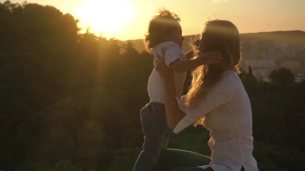 Portret syn i jego matka, przytulanie i całując w parku w zachód słońca. Szczęśliwa rodzina koncepcja. zdrowi ludzie na zewnątrz — Wideo stockowe