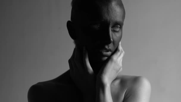 Retrato en blanco y negro de una hermosa joven mujer de piel pintada de negro cogida de la mano detrás de su cuello . — Vídeos de Stock