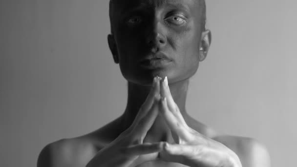 Retrato de moda en blanco y negro de una hermosa joven mujer de piel pintada de negro cogida de la mano formando un triángulo por su cara y mirando a la cámara — Vídeos de Stock