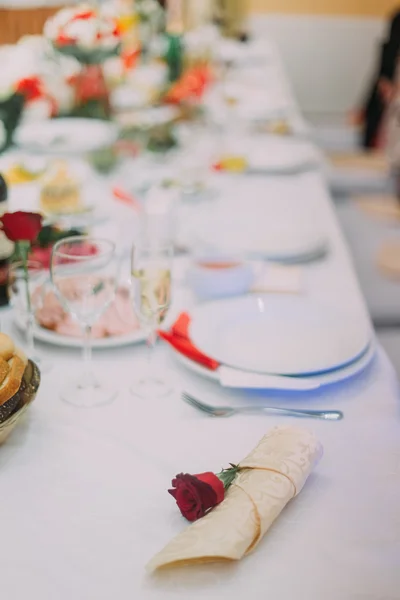 Guardanapo com rosa deitado em luxuoso servido mesa de jantar de catering — Fotografia de Stock