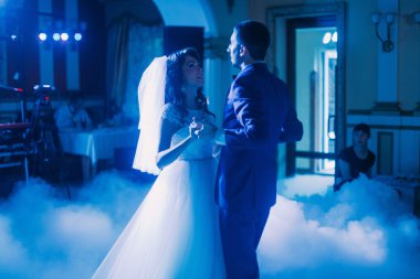 Yeni evli çift ilk düğün dansı. Koridorun beyaz duman ile kaplı ve Mavi ışıklar dolu