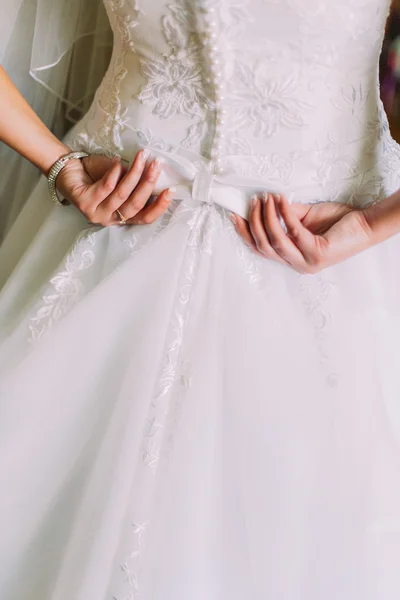 Primer plano de elegante, novia en vestido blanco vintage fijación de su vestimenta en los preparativos de la boda. Vista trasera —  Fotos de Stock