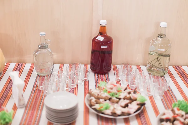 Mesa de catering de estilo rural no restaurante. Concentre-se em sanduíches de porco e copos cheios de bebidas alcoólicas — Fotografia de Stock