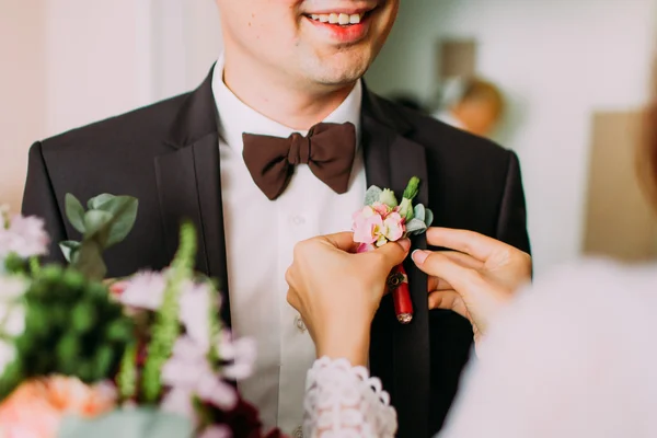 Деликт невесты руки булавки розовый и фиолетовый бутоньерка жениха смокинг — стоковое фото