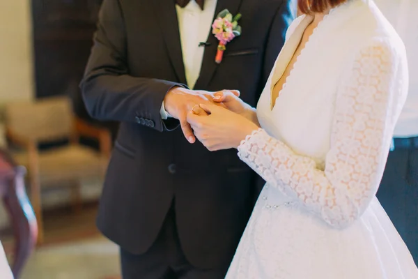 Свадебная церемония стильной элегантной невесты и счастливого жениха, надевая кольца в старой церкви — стоковое фото