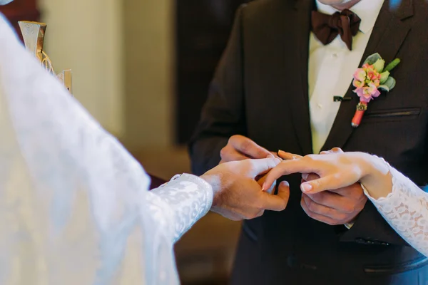 Священник надевает кольцо на палец невесты во время православной свадебной церемонии — стоковое фото