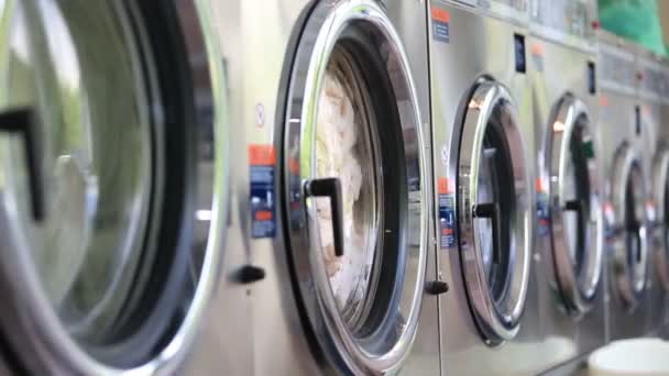 Washing machines at laundry washes colored clothing, and sheets — Stock Video