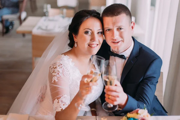Heureux jeunes mariés boit champagne et embrasser célébrer leur nouvelle vie conjugale — Photo