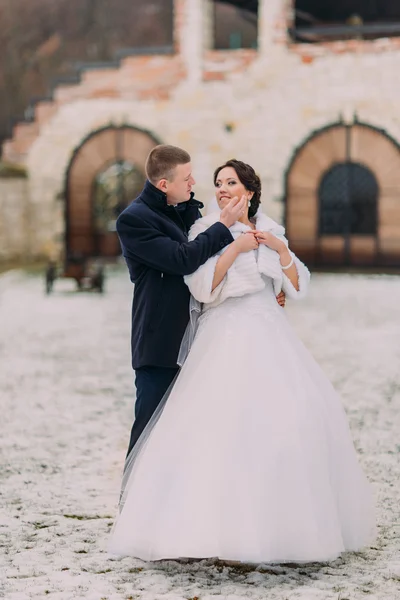 Retrato de boda de invierno. Amoroso joven novio suavemente tocando su encantadora cara de esposas —  Fotos de Stock