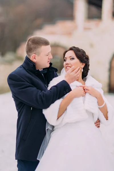 Vinter bröllop porträtt. Kärleksfull brudgummen försiktigt röra hans charmiga frus ansikte — Stockfoto