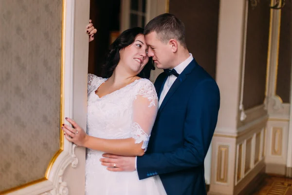 Feliz casal recém-casado abraçando no luxuoso interior do vintage — Fotografia de Stock