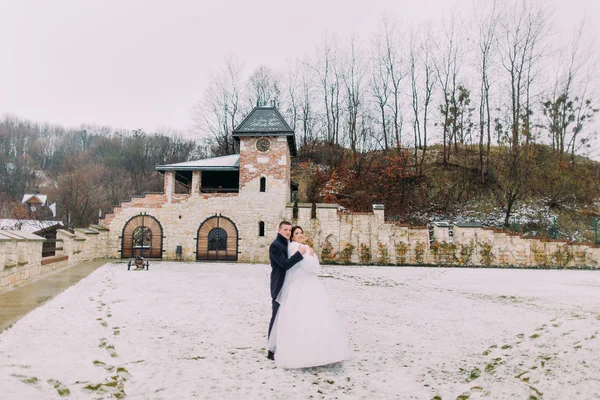 Winter wedding portrait. Happy newlyweds embracing in snowed up park — Stock Photo, Image