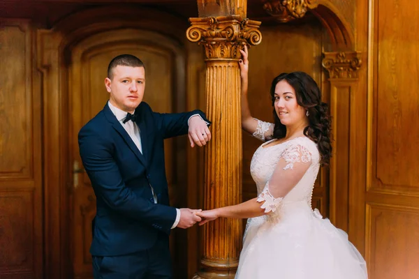 Retrato de família de noiva elegante e noivo em rico interior na velha mansão clássica — Fotografia de Stock