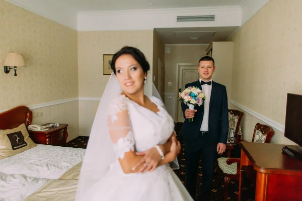 Enloved damat güzel gelini otel odasında bir buket vermek. Yeni evliler balayına — Stok fotoğraf