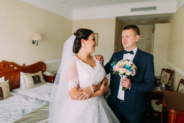 Recém-casados posando no quarto de hotel após a cerimônia de casamento. Conceito de lua de mel — Fotografia de Stock