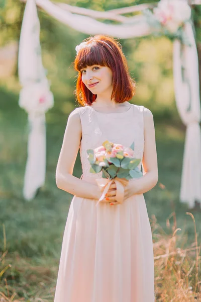 Gyönyörű vörös fej menyasszony szabadban portré virágok, dekoratív ív a háttérben — Stock Fotó