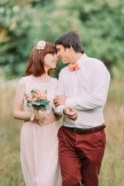 Närbild, par i skogen. Brud och brudgum går på kanten av skogen på bröllopsdag — Stockfoto