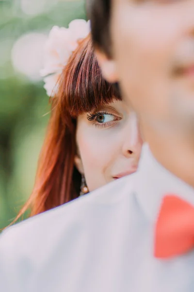 Κοντινό-up πορτρέτο της όμορφης κοκκινομάλλα νύφη χαμογελάει κοιτάζοντας μακριά, ενώ στέκεται το γαμπρό της — Φωτογραφία Αρχείου