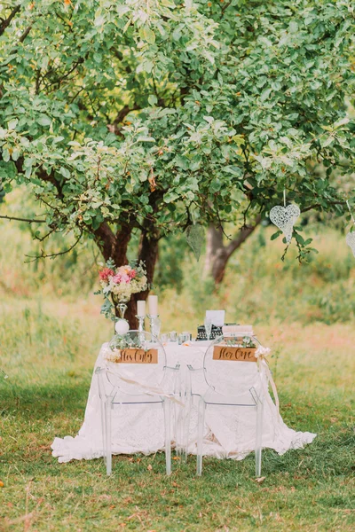 Decoração de casamento na floresta. Cerimônia rústica no parque, mesa e cadeiras, itens decorativos, arranjos de flores — Fotografia de Stock