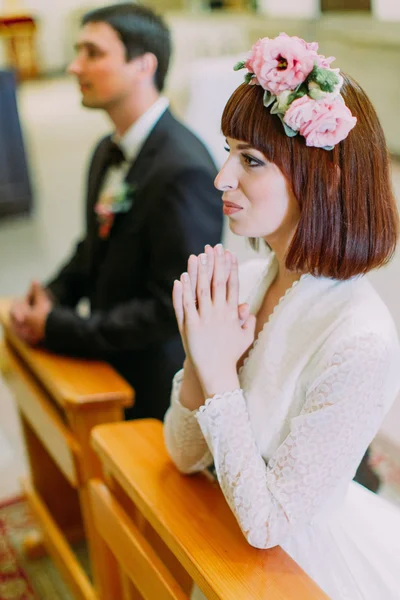 Novia y novio preparándose para la comunión de rodillas en la ceremonia de boda en la iglesia —  Fotos de Stock