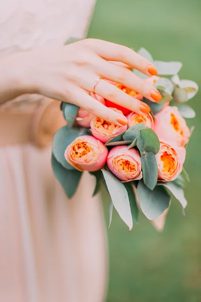 Nahaufnahme schöne florale Komposition in den Händen eines jungen Mädchens in rosa Kleid. — Stockfoto