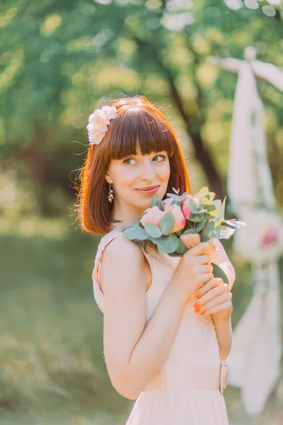 Hermosa novia pelirroja linda con ramo de flores en el fondo de un arco para salir de la ceremonia — Foto de Stock