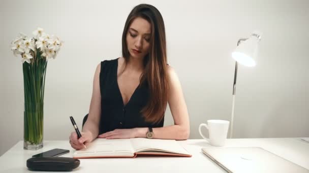 Genç esmer seksi iş kadını seductively beyaz ofis zemin üzerine kalem ile çalış. — Stok video