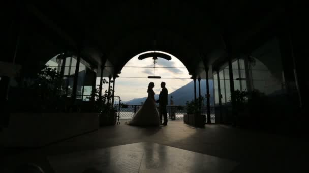 Silhouetten van bruidspaar zoenen in het paleis. Como, Italië — Stockvideo