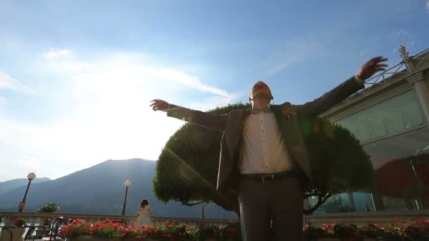 Novio feliz sthretching al sol, Lago de Como, Italia — Vídeos de Stock