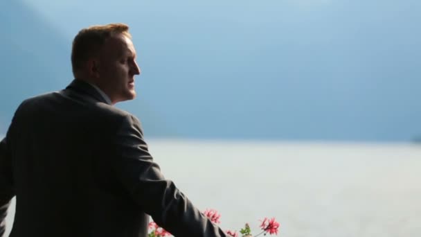 Portrait de beau marié regardant une vue imprenable sur le lac de Côme, Italie gros plan — Video