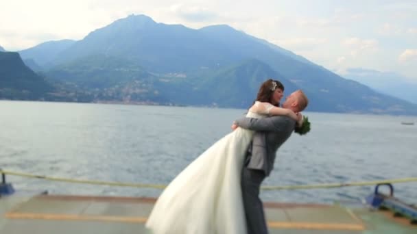 結婚式のカップルが桟橋にキスします。イタリアのコモでの新婚旅行 — ストック動画
