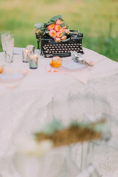 Романтична чорна друкарська машинка і рожеві квіти як прикраса для весільної фотосесії — стокове фото