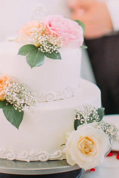 Nahaufnahme einer köstlichen weißen Hochzeitstorte mit rosa Rosen — Stockfoto