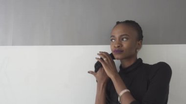 Uzakta gri arka planı arıyorum parlak mor dudaklar ile gülümseyen genç Afrikalı kadın portresi