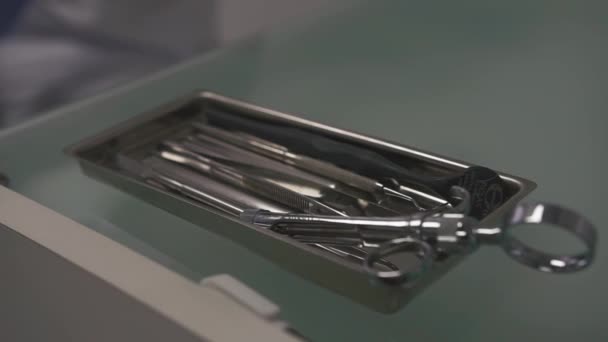 Mano en guantes médicos toma instrumento quirúrgico dantista de caja en la clínica durante los procedimientos estomatológicos — Vídeos de Stock