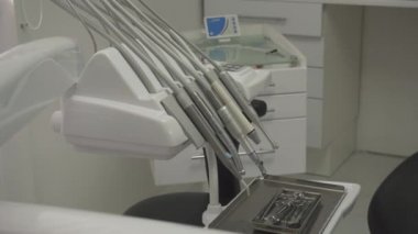 Diş hekimi aletlerinin yakın çekim. Metal tepsi, çapak makinesi, birincil mavi ışık lambası ve diğer ekipmanlarpaslanmaz çelik aletler