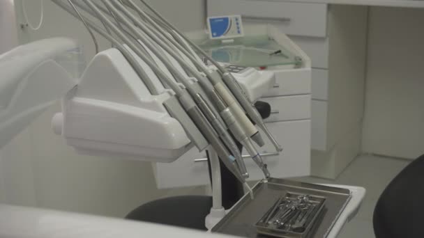 Närbild av tandläkare verktyg. Rostfrittstål instrument i metall bricka, Burr maskin, primär blå lampa och annan utrustning — Stockvideo