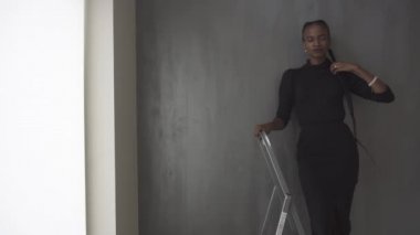 Genç oldukça siyah Amerikalı kadın onun kalın örgü karanlık studio arka plan üzerinde dokunmadan