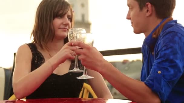 Young loving couple drinking wine and kissing on the rooftop of ancient city building while raining — Stock Video