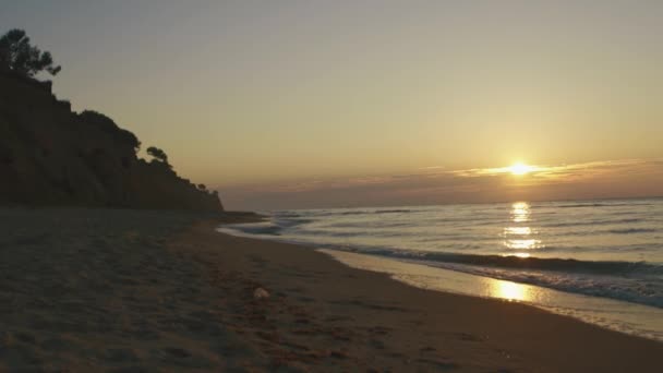 Ondas silenciosamente rolando na praia de areia ao pôr-do-sol silencioso. Conceito de calma no mar — Vídeo de Stock