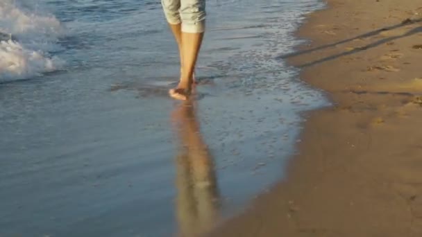 Primo piano di gambe di uomo che corrono lungo la costa della spiaggia. Rallentatore — Video Stock