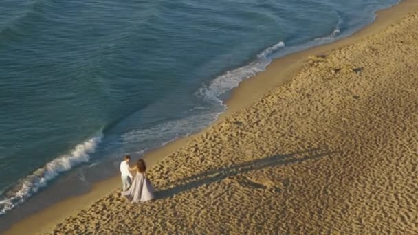 Ein elfjähriges Paar, das abends am Strand spazieren geht. Romantisches Paar schlendert Händchen haltend — Stockvideo