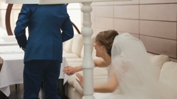 Grappig moment van mooie bruid aanraken bruidegoms kont en glimlachend — Stockvideo
